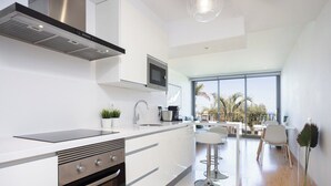 A modern kitchen with a built-in oven, a microwave, and a large window overlooking a balcony.