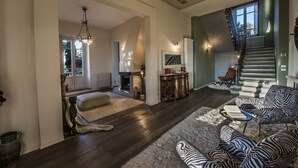 A spacious living room with a fireplace, a staircase, and a view of the outdoors. - Villa del Poeta - Homelike Villas (Loro Ciuffenna)