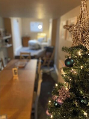 Cozy room with a dining area, comfortable bed, and festive touches.