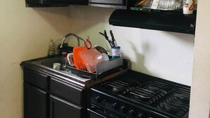 A compact kitchen with a sink, stove, and microwave. - Come, Relax and feel at Home (Tijuana)