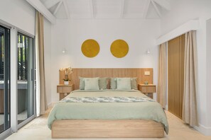 Ein modernes Schlafzimmer mit einem großen Bett, einem hölzernen Kopfteil, zwei runden Wanddekorationen und einer Schiebeglastür, die zu einem Außenbereich führt.