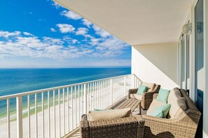 A balcony with wicker furniture and a view of the ocean. - Lighthouse 1511 | Gulf Shores, AL (Gulf Shores)