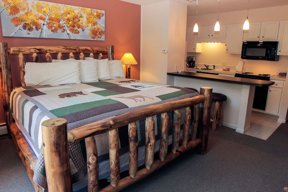 Suite features King bed, full kitchen, and deck with a river view.