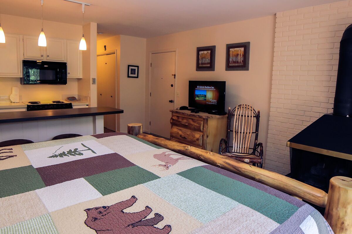 Suite features King bed, full kitchen, and deck with a river view.
