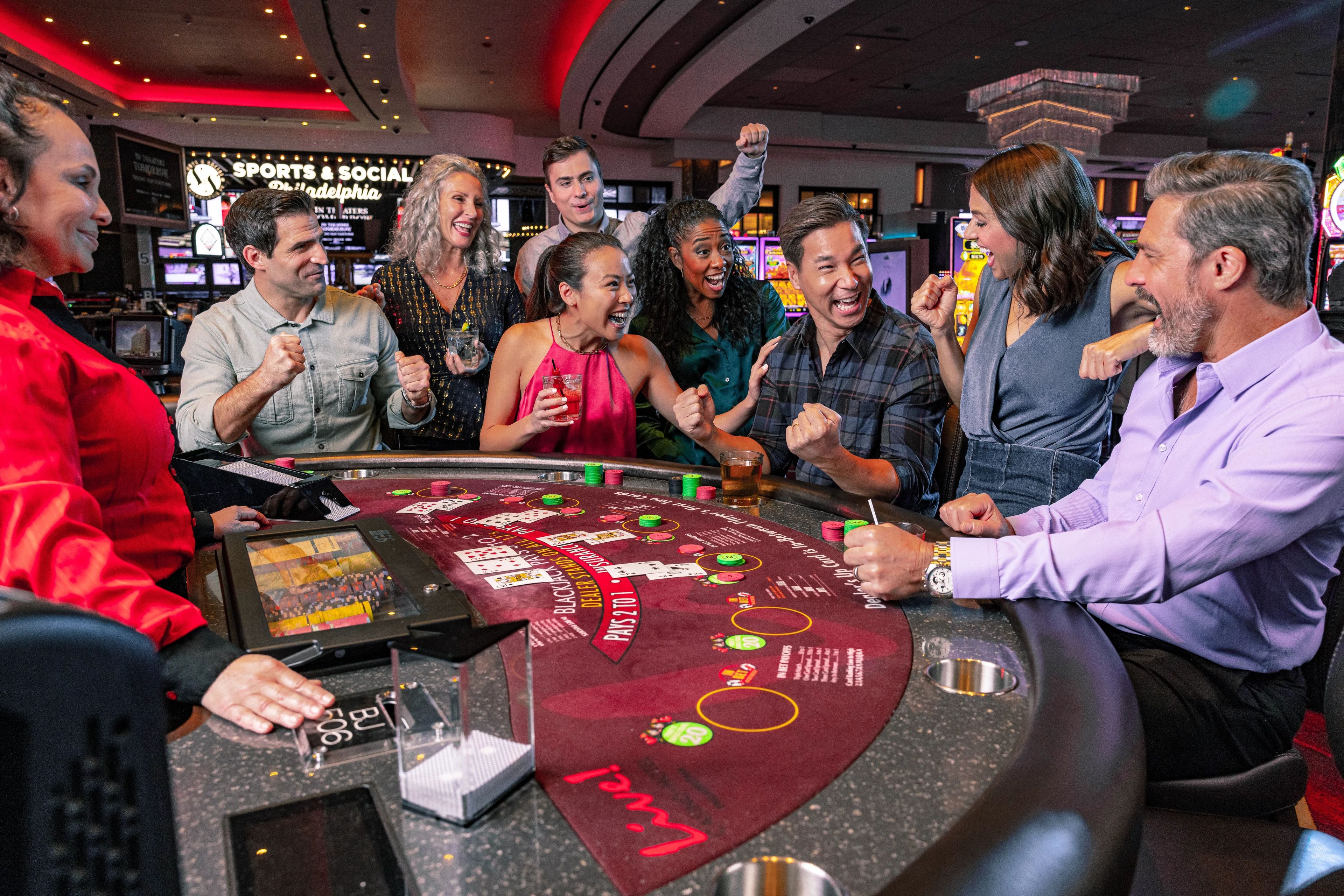 Un grupo de personas en una mesa de blackjack en un casino, con un crupier.