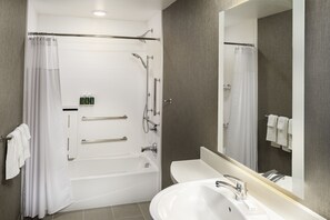A modern bathroom with a bathtub, shower, and sink. - SpringHill Suites by Marriott Irvine Lake Forest (Lake Forest)