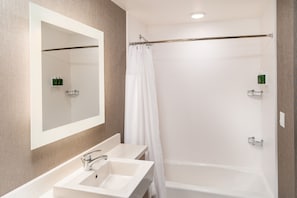 A modern bathroom with a white sink, mirror, and bathtub. - SpringHill Suites by Marriott Irvine Lake Forest (Lake Forest)