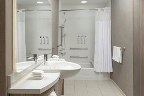 A modern bathroom with a large sink, mirror, and shower area. - SpringHill Suites by Marriott Irvine Lake Forest (Lake Forest)