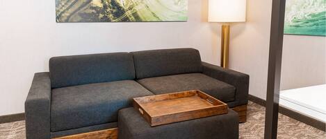 Un salon moderne avec un canapé gris, une table basse en bois et un lampadaire.