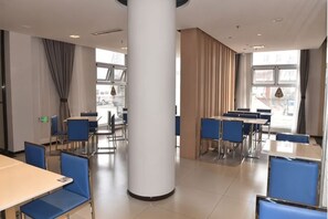 A spacious indoor area with tables and chairs, large windows, and a central pillar. - JinJiang Inn Taiyuan Qingxu County Government Hotel (Qingxu)