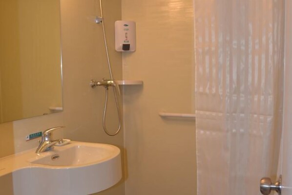 A bathroom with a sink, a mirror, a shower, and a towel rack. - JinJiang Inn Taiyuan Qingxu County Government Hotel (Qingxu)