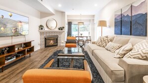 A modern living room with a fireplace, a flat-screen TV, a sofa, and a dining area. - #1 Park City Ski-In Ski-Out Luxury, Giant Porch, the Most Amenities, near Main! (Park City)