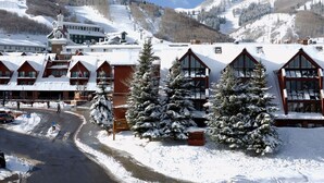 A snow-covered lodge with multiple buildings, a ski slope in the background, and a clear sky. - #1 Park City Ski-In Ski-Out Luxury, Giant Porch, the Most Amenities, near Main! (Park City)