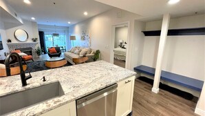 A modern kitchen with a granite countertop, stainless steel appliances, and a dining area with a sofa and chairs. - #1 Park City Ski-In Ski-Out Luxury, Giant Porch, the Most Amenities, near Main! (Park City)