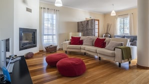 A living room with a fireplace, two sofas, a coffee table, and a TV.