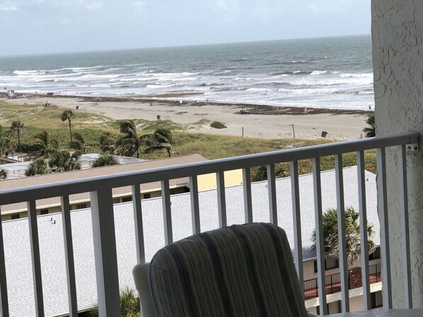 A balcony with a view of the ocean and beach.