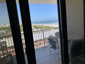 A balcony with a view of the beach and ocean.