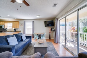 Relax in this stylish living space with a sofa, dining area, and kitchen, plus a balcony with outdoor views.