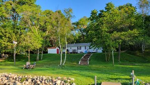 A lakeside cabin with a dock, surrounded by trees and a grassy area. - Comfortable & clean cabin on beautiful 3rd Crow Wing Lake in Hubbard County MN. (Nevis)