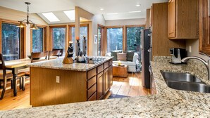 A spacious kitchen with a large island, wooden cabinets, and a granite countertop.