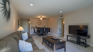 A living room with a sofa, coffee table, TV, and dining area with chairs and a table. - SCOTTSDALE CONDO/OLDTOWN ACROSS STREET FROM FASHION SQUARE MALL...NEW REMODEL (Scottsdale)