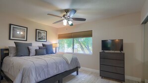A bedroom with a bed, a ceiling fan, a dresser, and a TV. - SCOTTSDALE CONDO/OLDTOWN ACROSS STREET FROM FASHION SQUARE MALL...NEW REMODEL (Scottsdale)