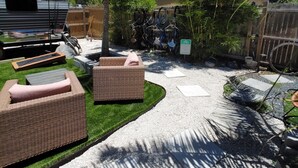 A backyard with outdoor furniture, a gravel path, and a bicycle rack. - Tiny House , Big Vibes Illuminated Backyard Escape (St. Petersburg)