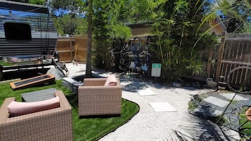 A backyard with outdoor furniture, a gravel path, and a bicycle rack.