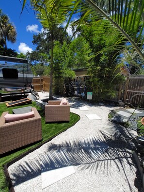 A backyard with outdoor furniture, a gravel path, and a bicycle rack.