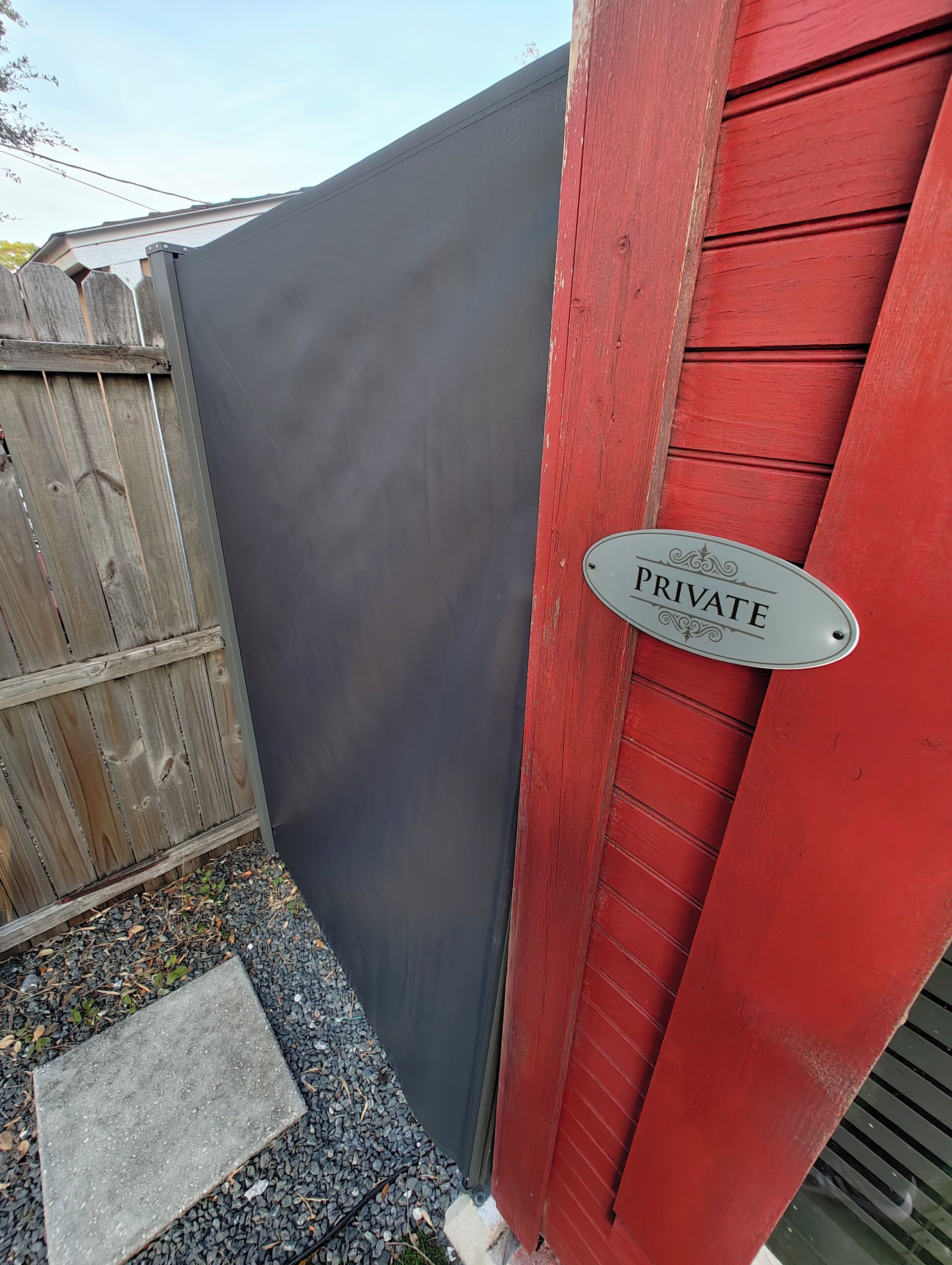 A private property with a dark fence, a red door, and a 'PRIVATE' sign.