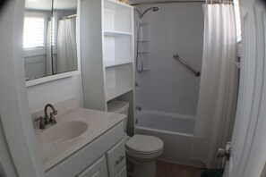 Un baño con lavamanos, inodoro y ducha.