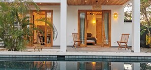A modern house with a pool, wooden furniture, and a cozy interior.