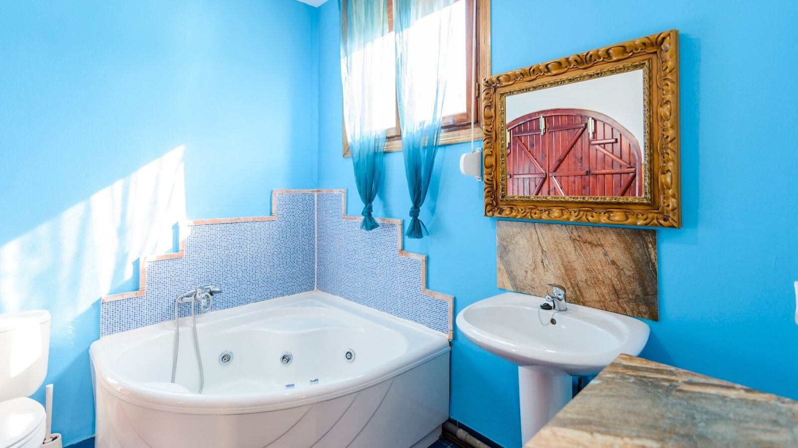 Un baño con bañera, lavamanos y espejo.
