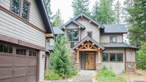 A two-story house with a stone facade, a wooden front porch, and a garage. - Golf View, Game Room, Suncadia Pool Access (Cle Elum)