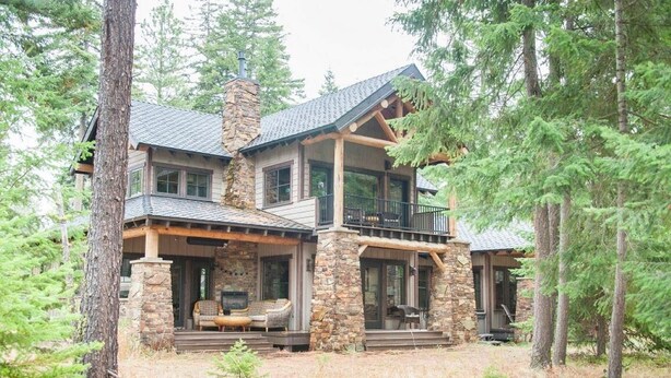 A two-story log cabin with stone accents, a balcony, and a porch with outdoor seating. - Golf View, Game Room, Suncadia Pool Access (Cle Elum)