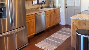 A modern kitchen with stainless steel appliances, wooden cabinets, and a built-in dishwasher. - Quiet 3 acre Ranch Home with incredible mountain views!! (Tucson)