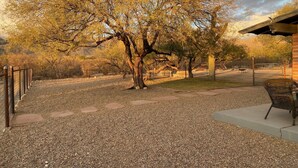 A gravel path leading to a fenced area with a bench and a building in the background. - Quiet 3 acre Ranch Home with incredible mountain views!! (Tucson)