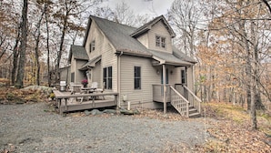 A two-story house with a deck, surrounded by trees. - Wintergreen Resort Cabin: Near the Slopes! (Wintergreen Resort)