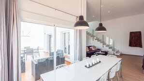 A modern interior with a dining area, a sofa, and a staircase. - Villa Esperanza Canillas de Albaida by Ruralidays (Málaga)