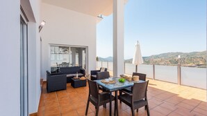 A terrace with a dining area, seating, and a view of the landscape. - Villa Esperanza Canillas de Albaida by Ruralidays (Málaga)