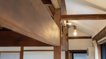 Eine Holzbalkendecke mit sichtbaren Trägern und einer hängenden Leuchte.