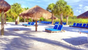 A beach with thatched umbrellas and blue lounge chairs. - Lovely 3BR 2 Bath Orlando Area Resort Condo (Davenport)