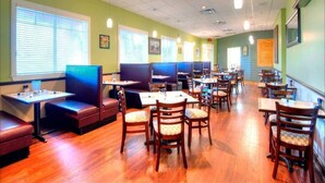 A restaurant with booths and tables, wooden flooring, and green walls. - Lovely 3BR 2 Bath Orlando Area Resort Condo (Davenport)