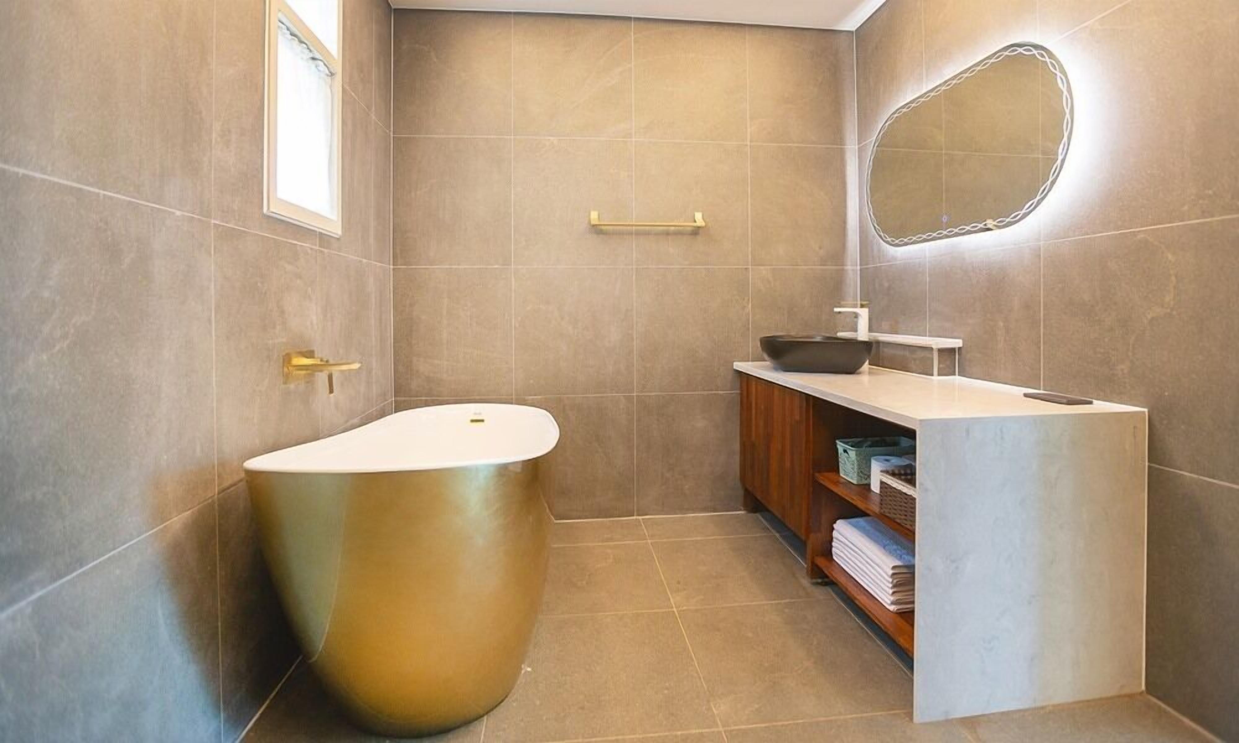 A modern bathroom with a freestanding bathtub, a vanity with a mirror, and a towel rack.