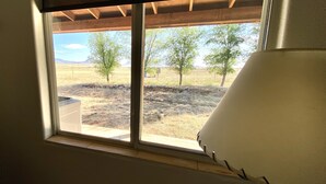 A room with a window overlooking a dry landscape with trees and mountains. - Sunset Ride Ranch /Foreman's house (Elgin)
