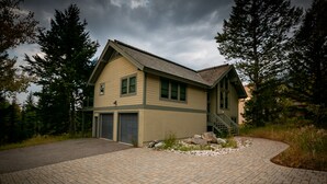 A two-story house with a garage, a covered porch, and a stone pathway leading to the entrance. - JHRL - Lookout Lodge, short walk to base of Jackson Hole Mountain Resort (Teton Village)