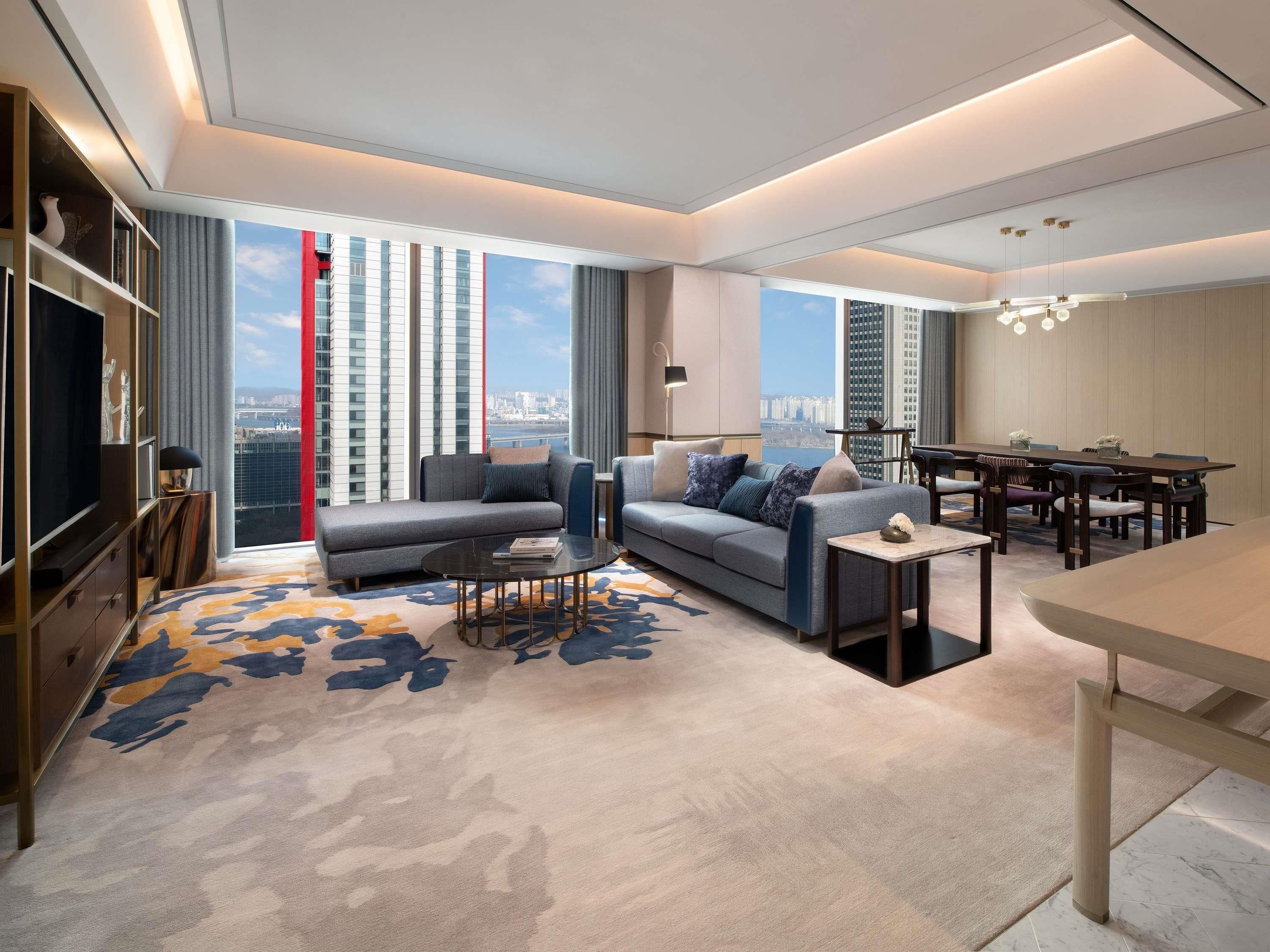 A modern living room with a sofa, coffee table, and dining area.