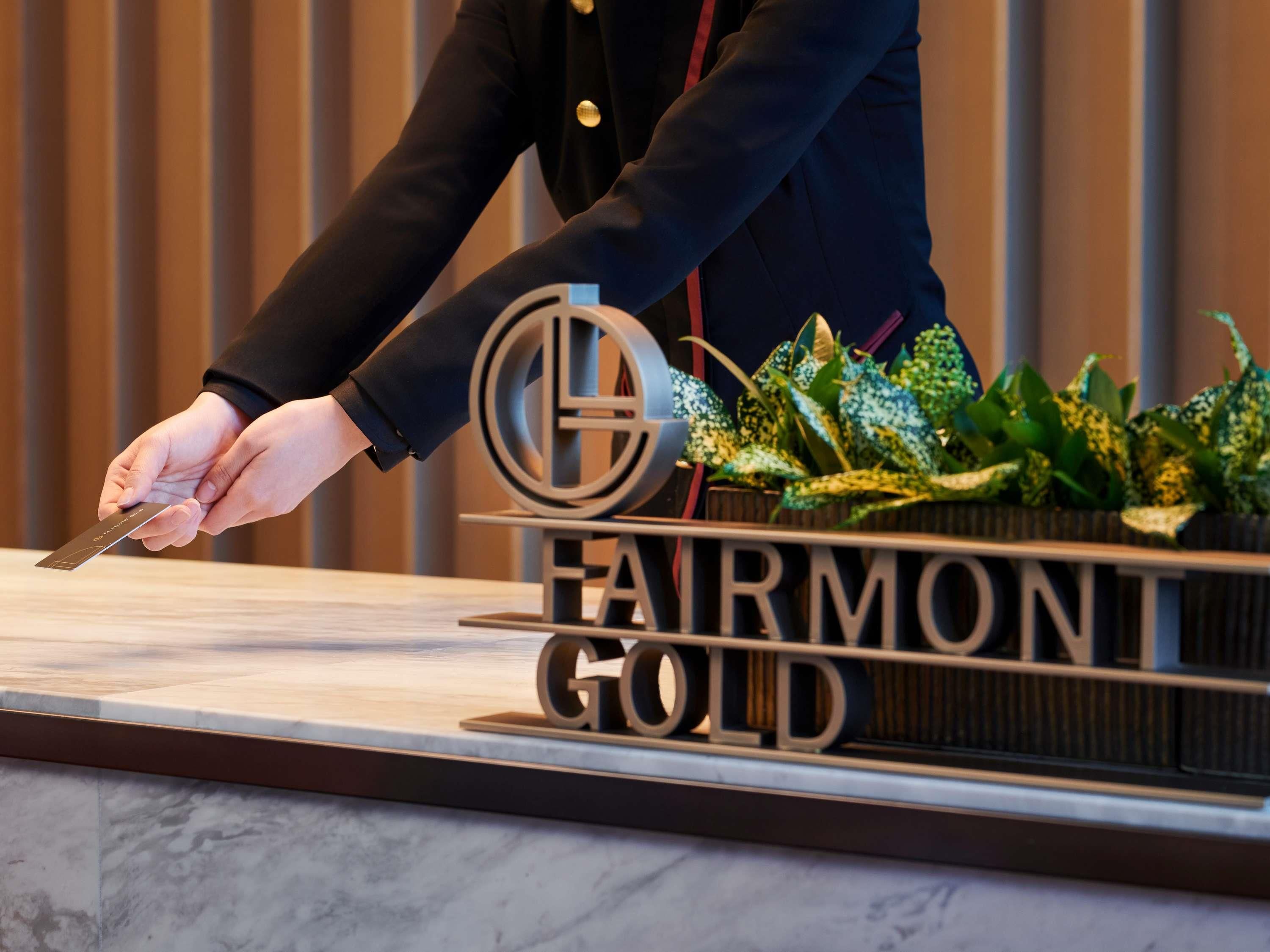 A person cutting a sign that reads "FARMONT GOLD" with a knife.