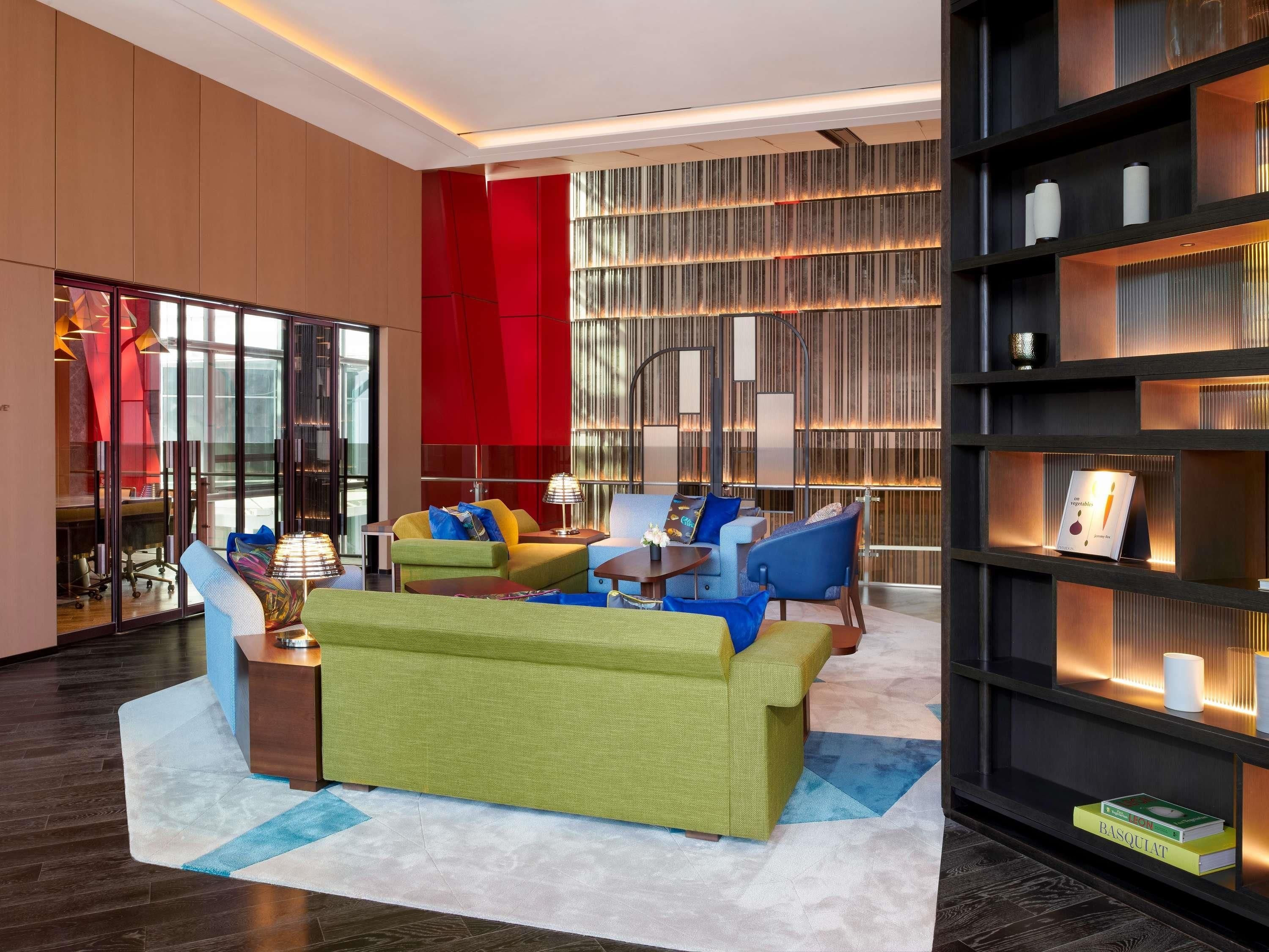 A modern living room with a sofa, chairs, and a bookshelf.