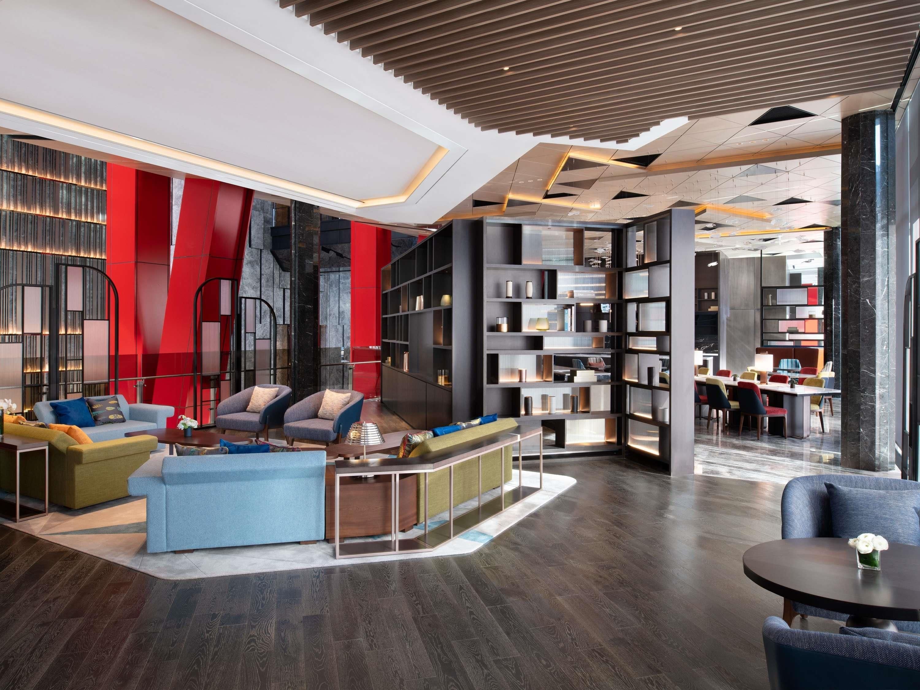 A modern lounge area with sofas, a coffee table, and a bookshelf.